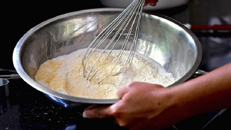 Cho bột mì, bột nở, đường, muối nở vào bát để trộn.